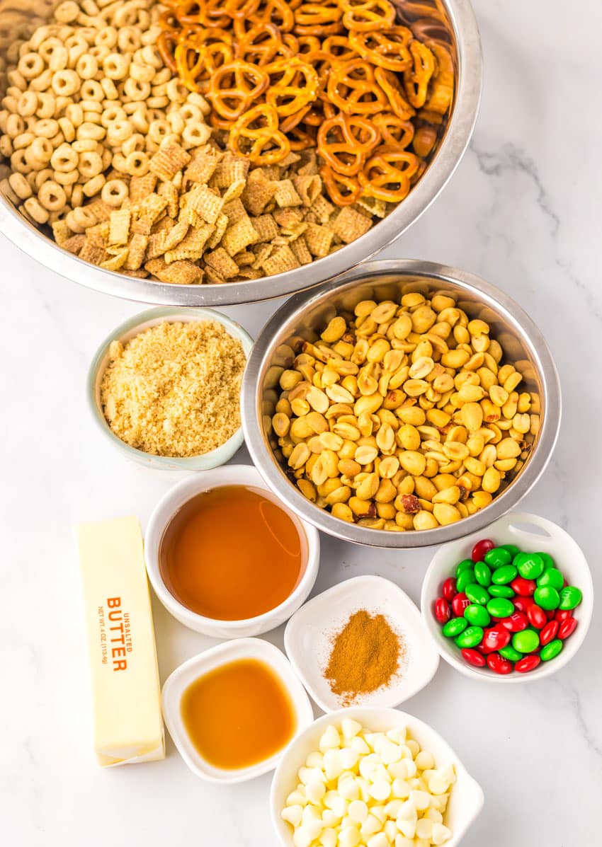 an overhead image showing the measured ingredients needed to make a batch of christmas chex mix in the slow cooker
