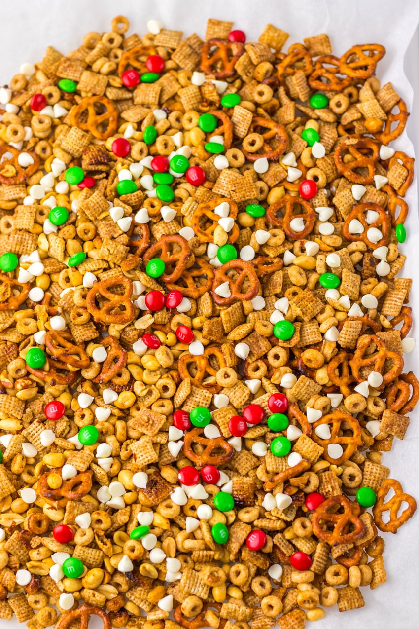 homemade christmas chex mix spread out on a sheet of white parchment paper