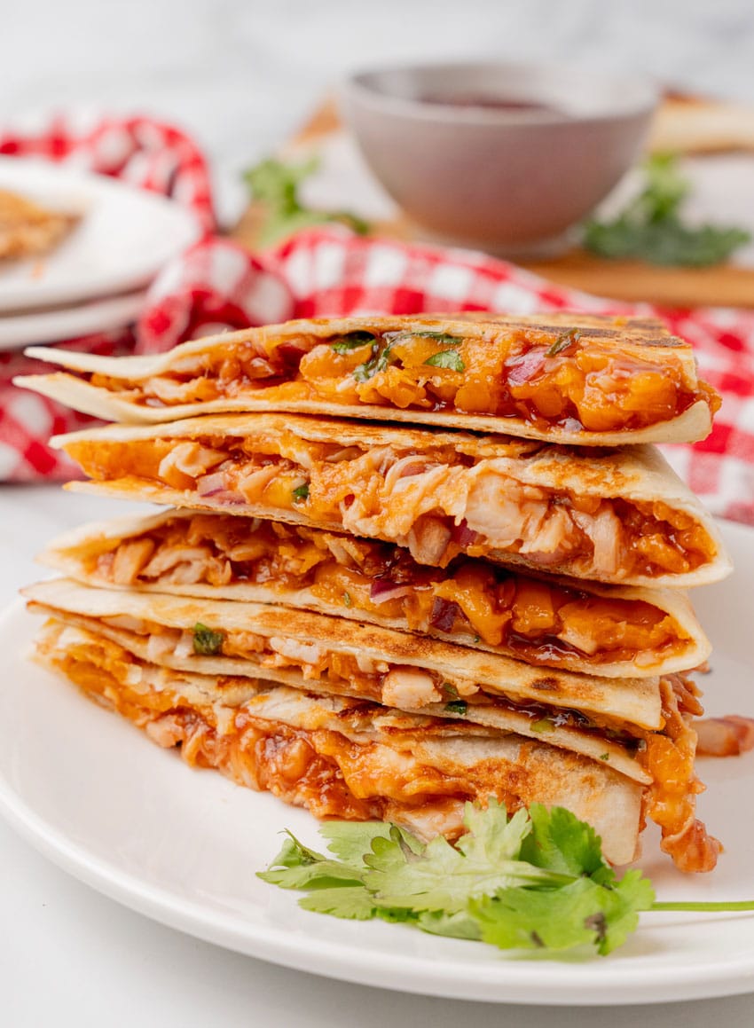 barbecue chicken quesadillas stacked on a white plate