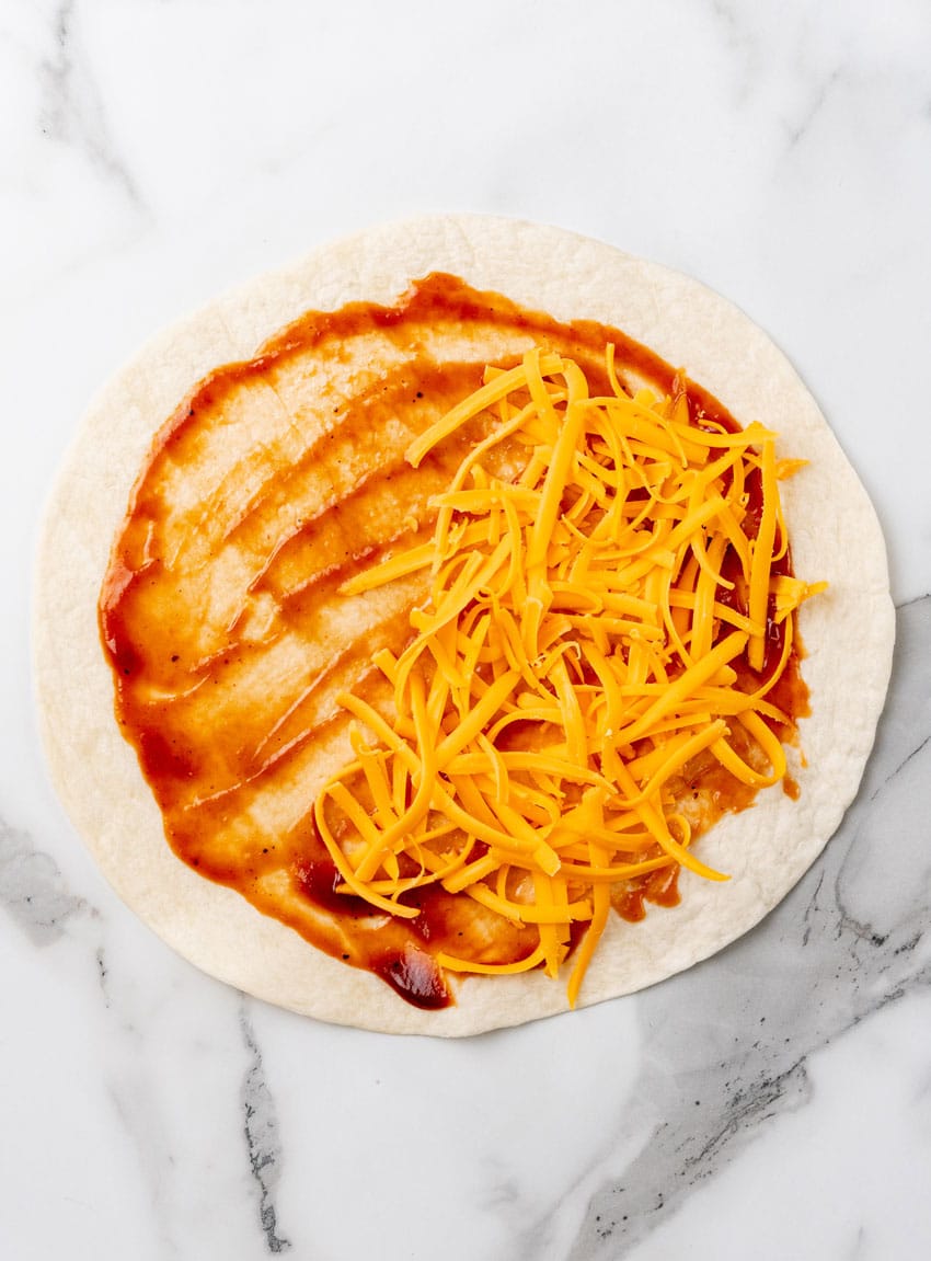 a barbecue chicken quesadillas being assembled on a marble countertop