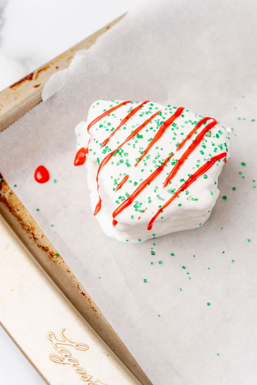 a copycat little debbie christmas tree cake on a parchment paper lined baking sheet pan
