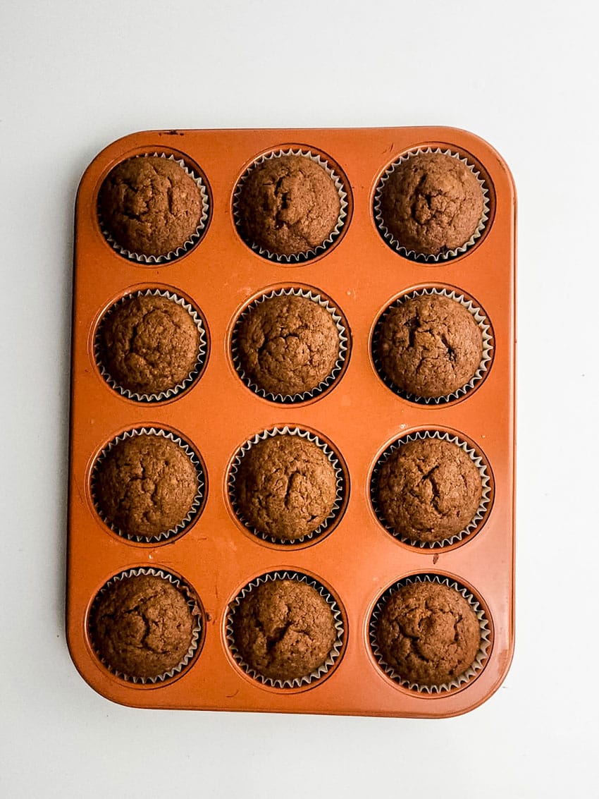 baked sweet potato cupcakes in an orange muffin tin