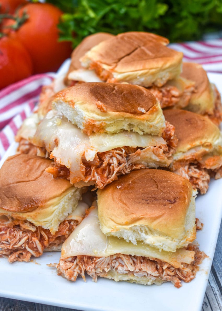 slow cooker chicken parmesan sliders stacked on a white serving platter