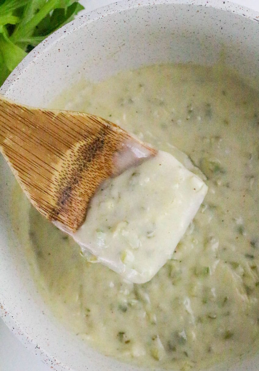 a wooden spatula holding up a scoop of homemade cream of celery soup