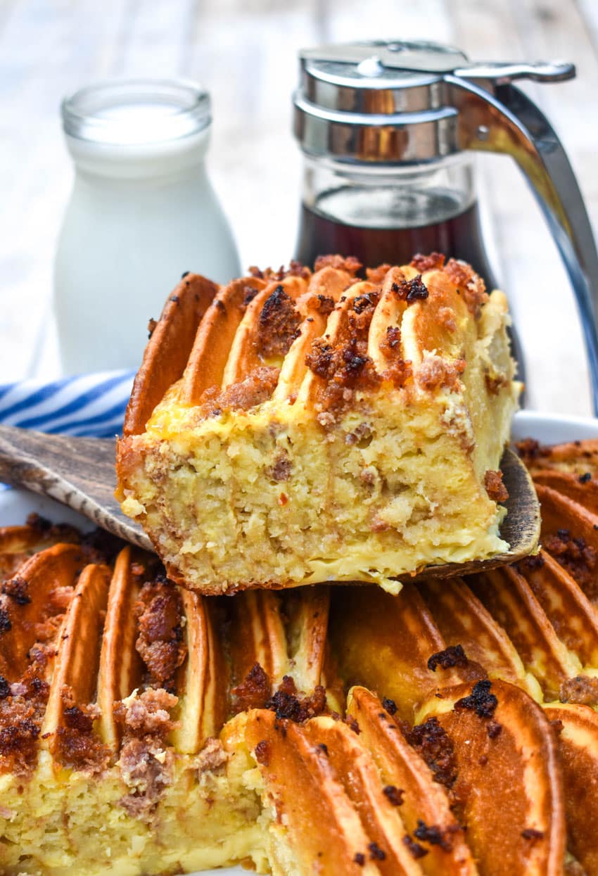 a wooden spatula holding up a slice of sausage and pancake casserole