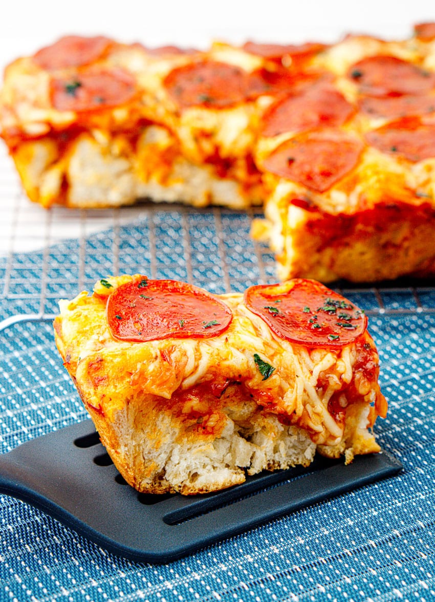 a slice of bubble up pizza casserole resting on a black spatula