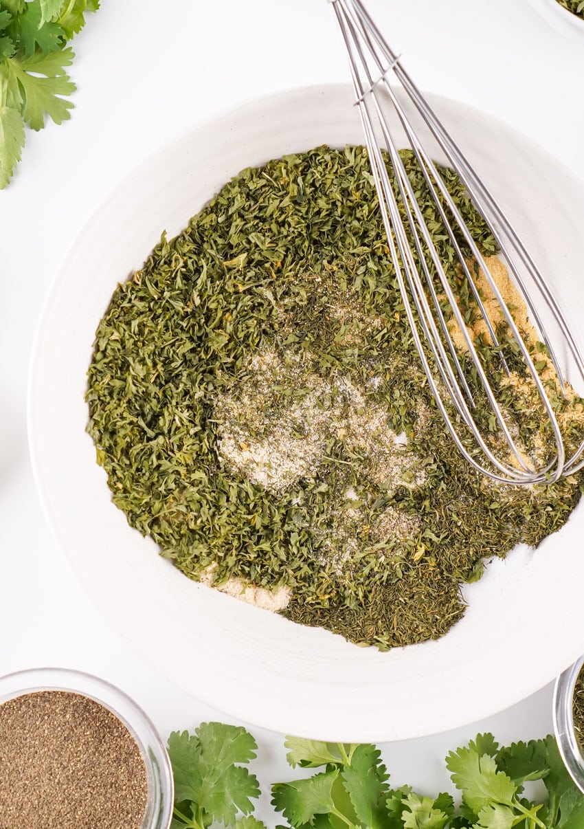 homemade ranch seasoning ingredients being whisked together in a small white bowl