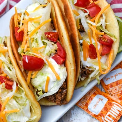 homemade beef chalupas arranged in a row on a white serving platter