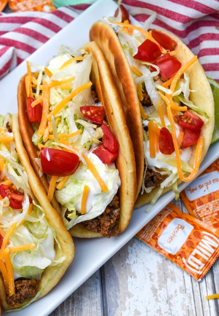 homemade beef chalupas arranged in a row on a white serving platter