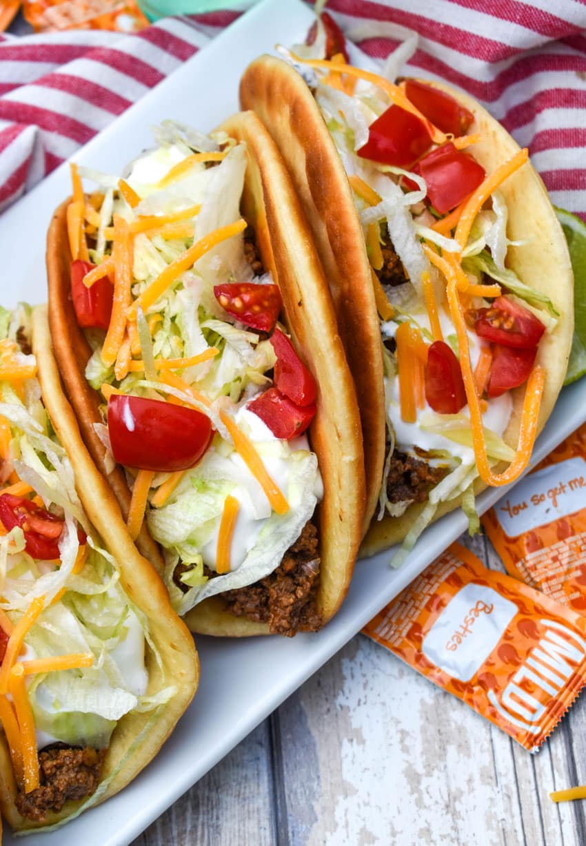 homemade beef chalupas arranged in a row on a white serving platter