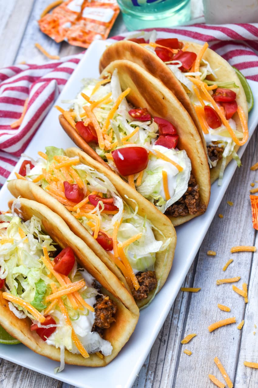 homemade beef chalupas arranged in a row on a white serving platter