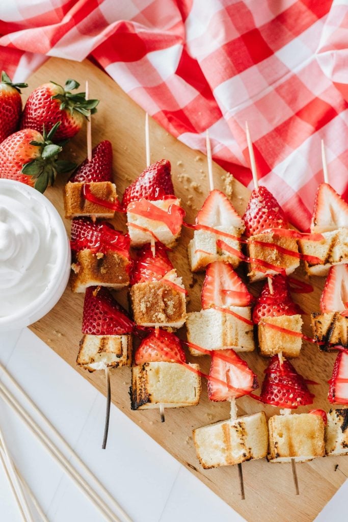 grilled strawberry shortcake kabobs on a wooden cutting board