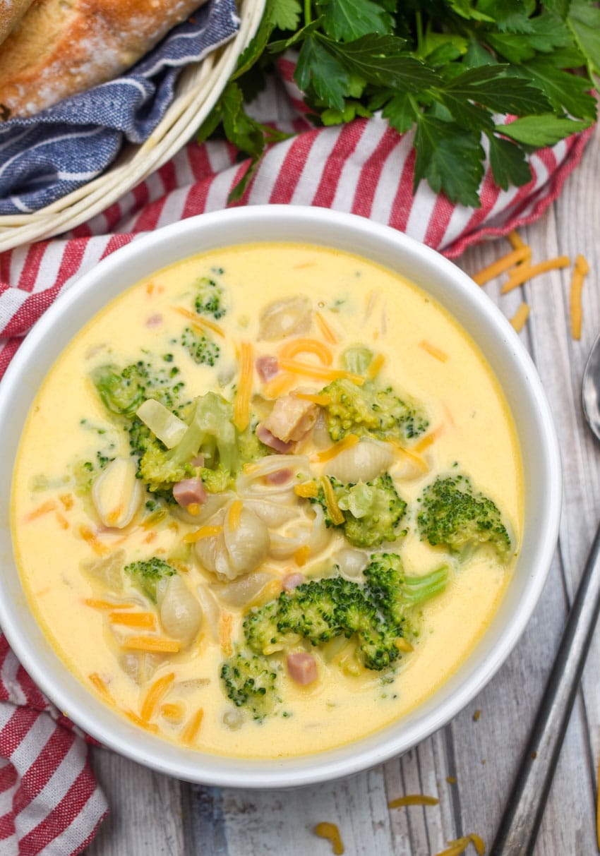 mac and cheese soup with ham and broccoli in a white bowl