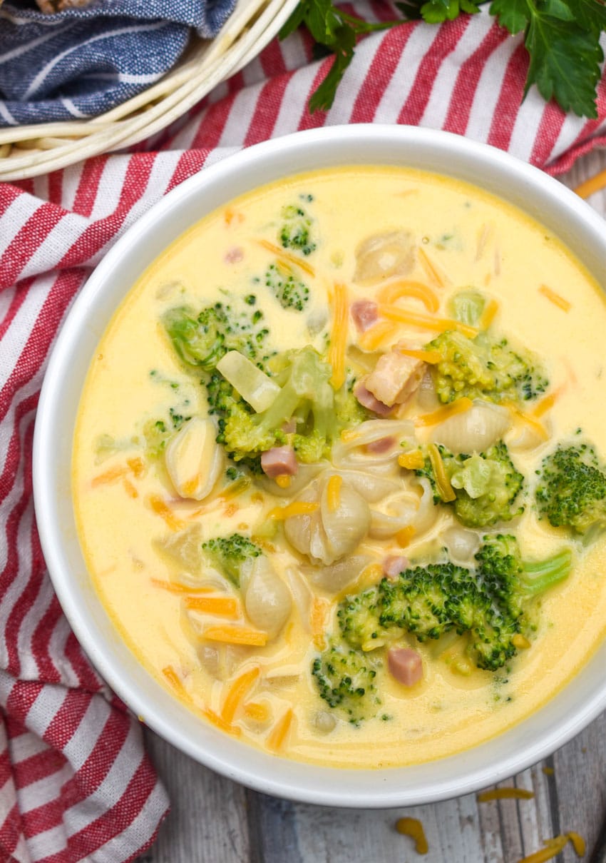 mac and cheese soup with ham and broccoli in a white bowl