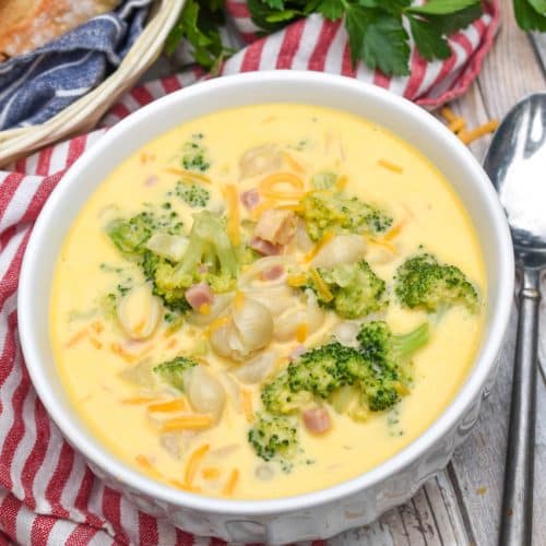 mac and cheese soup with ham and broccoli in a white bowl