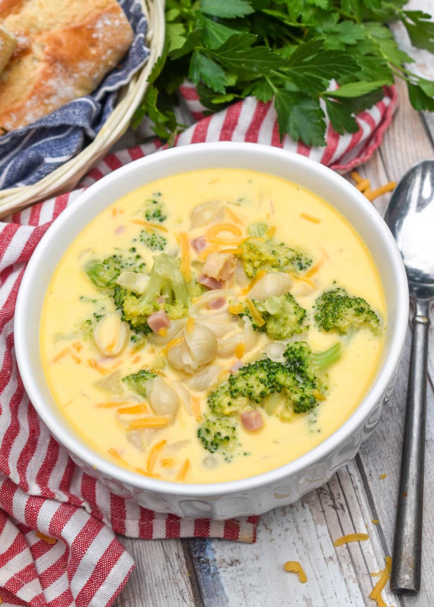 mac and cheese soup with ham and broccoli in a white bowl