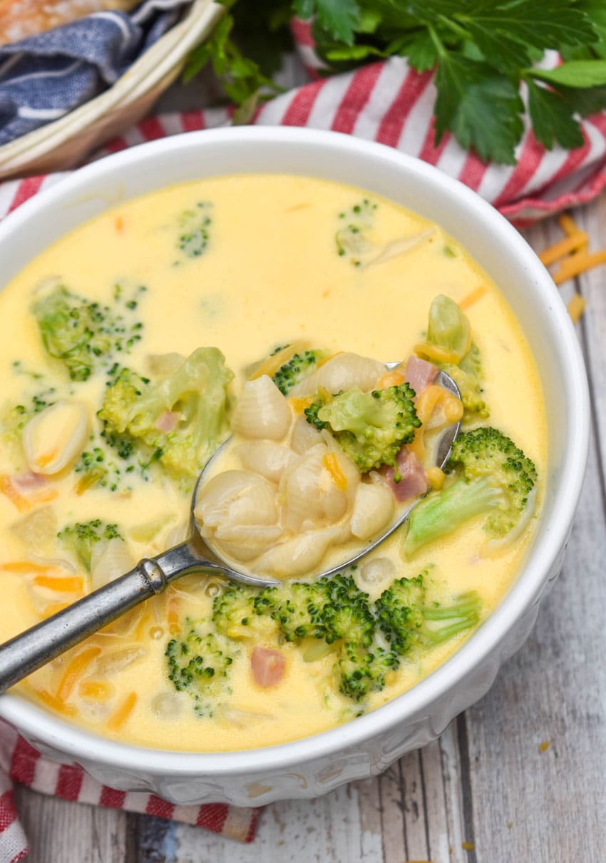 mac and cheese soup with ham and broccoli in a white bowl