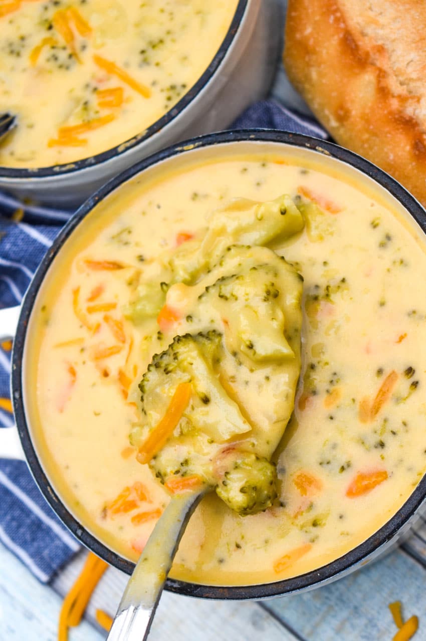 a silver spoon holding up a scoop of homemade broccoli cheddar soup