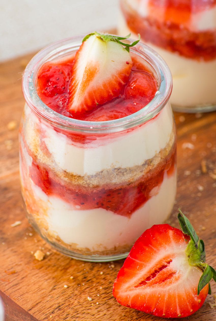 strawberry cheesecake cups on a wooden cutting board