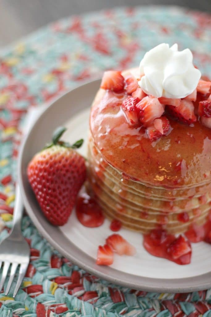 a stack of strawberry shortcake pancakes on a white plate