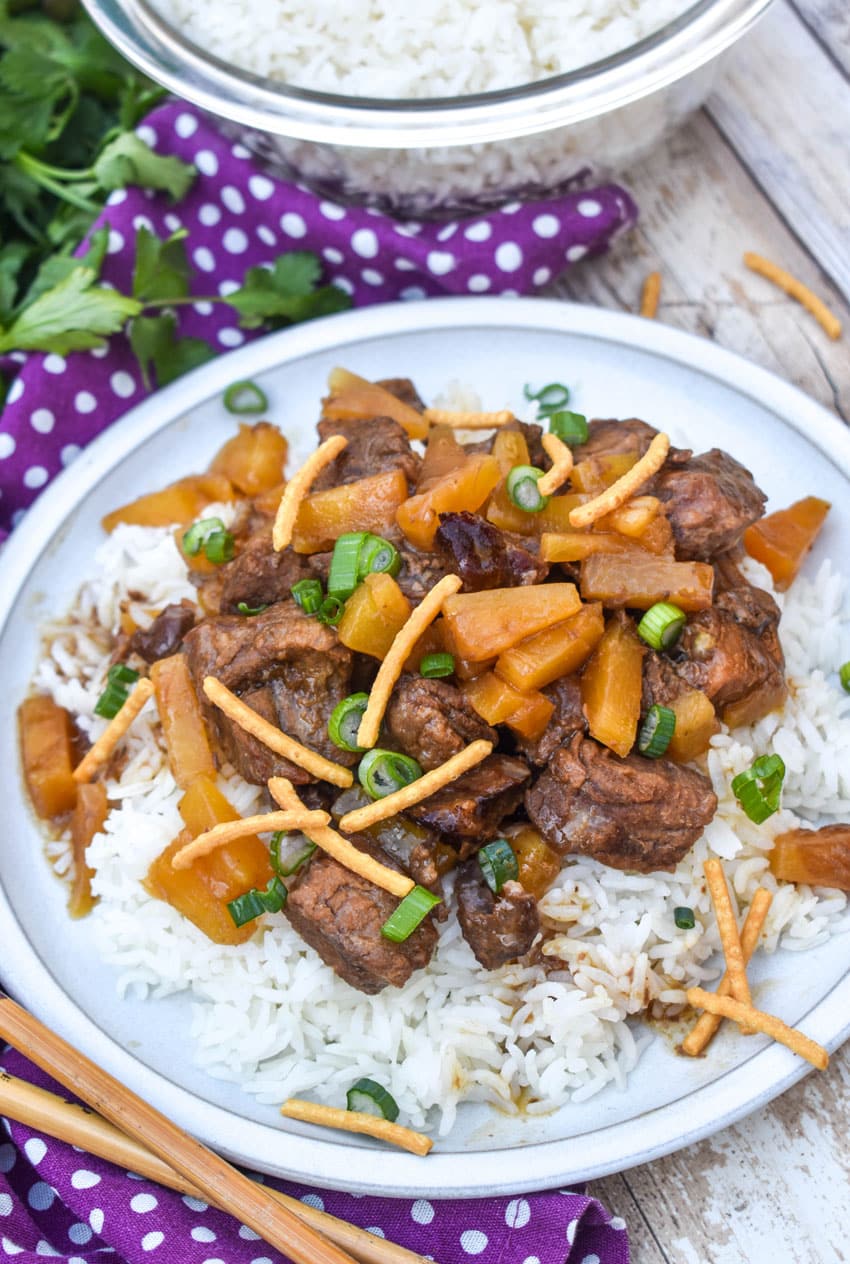 slow cooker steak teriyaki over steamed white rice on a white plate