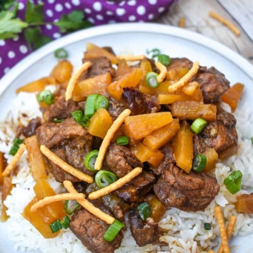 slow cooker steak teriyaki over steamed white rice on a white plate