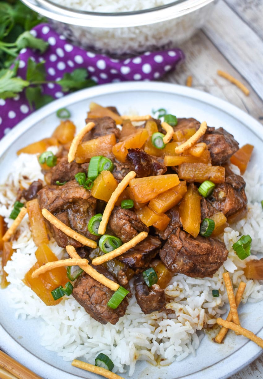 slow cooker steak teriyaki over steamed white rice on a white plate