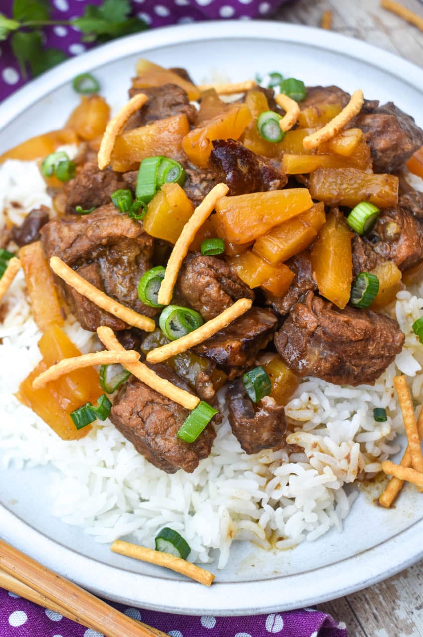 slow cooker steak teriyaki over steamed white rice on a white plate