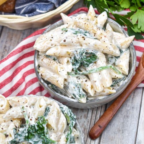 spinach dip pasta salad in two small gray bowls