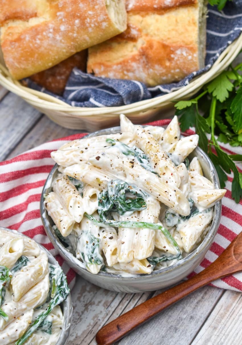 spinach dip pasta salad in two small gray bowls