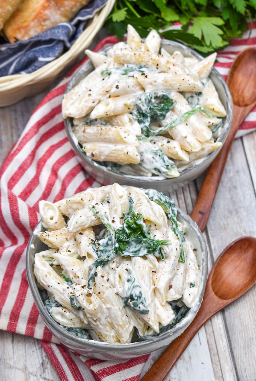 spinach dip pasta salad in two small gray bowls