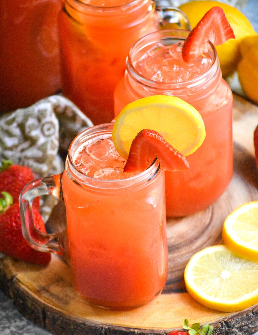 glasses of strawberry lemonade on a wooden cutting board