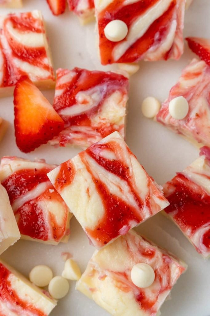 squares of strawberries and cream fudge on a marble countertop