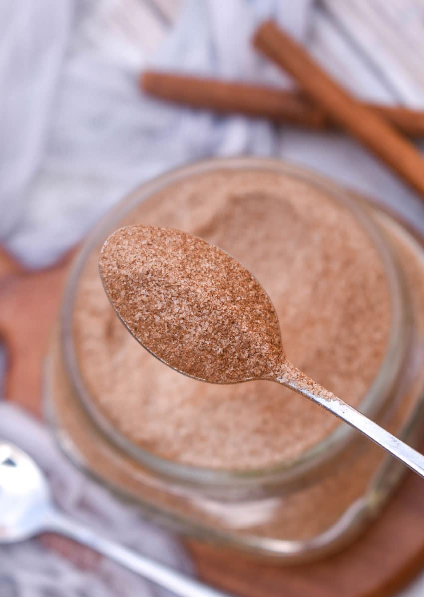a silver spoon holding up a scoop of homemade cinnadust seasoning