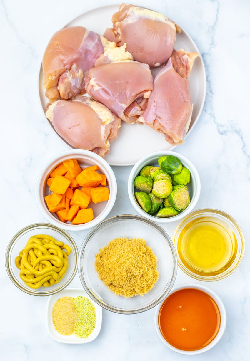 an overhead image showing the measured ingredients needed to make a batch of maple mustard chicken thighs with roasted vegetables