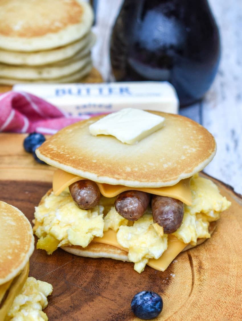 pancake egg and cheese sandwiches on a wooden cutting board