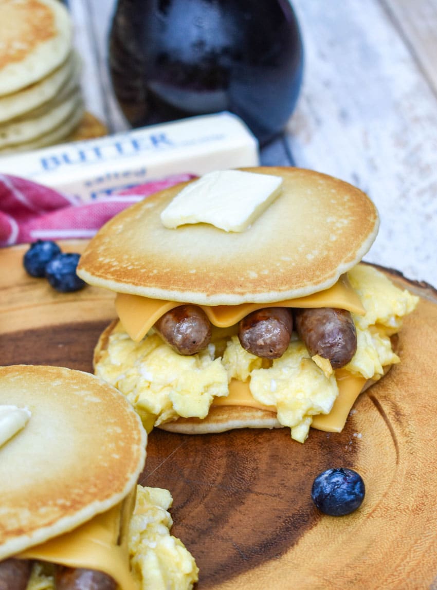 pancake egg and cheese sandwiches on a wooden cutting board