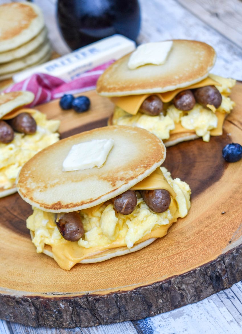 pancake egg and cheese sandwiches on a wooden cutting board
