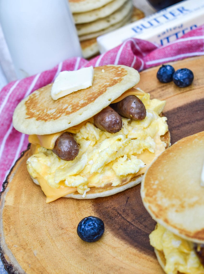 pancake egg and cheese sandwiches on a wooden cutting board