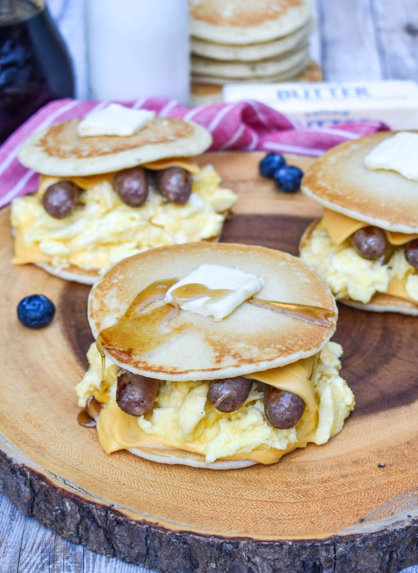 pancake egg and cheese sandwiches on a wooden cutting board