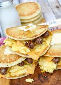 pancake egg and cheese sandwiches on a wooden cutting board