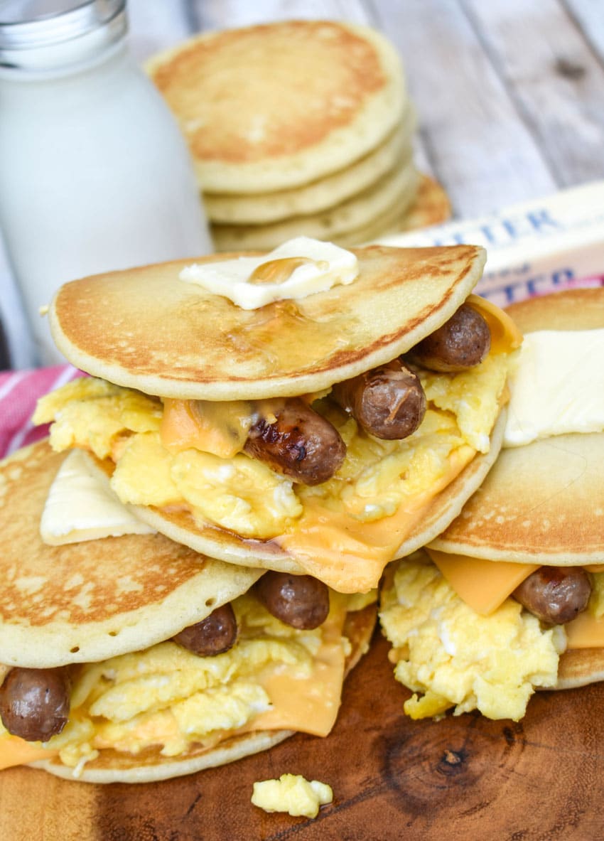 pancake egg and cheese sandwiches on a wooden cutting board