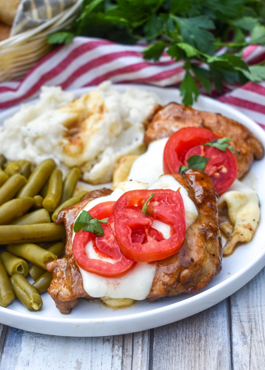 skillet balsamic chicken next to mashed potatoes and canned green beans on a white plate