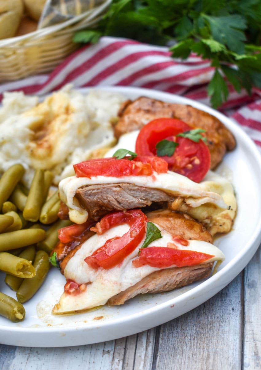 a piece of skillet balsamic chicken next to mashed potatoes and canned green beans on a white plate