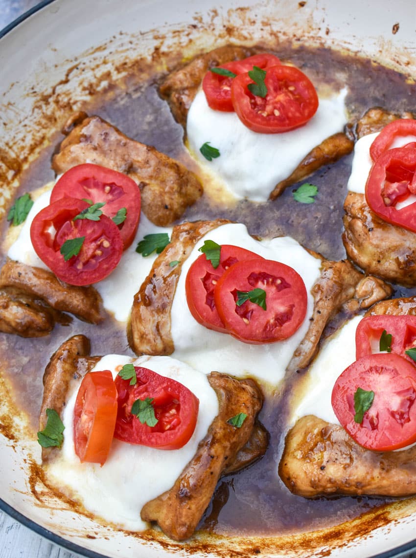 balasamic chicken with mozzarella and tomatoes in a large skillet
