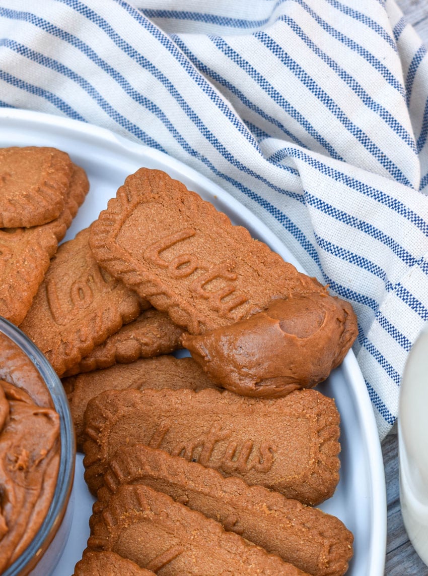 homemade cookie butter on a biscoff cookie resting on the edge of a white plate
