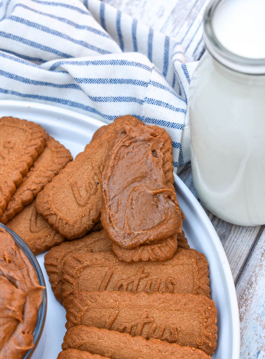homemade cookie butter spread on a biscoff cookie resting on the edge of a white plate