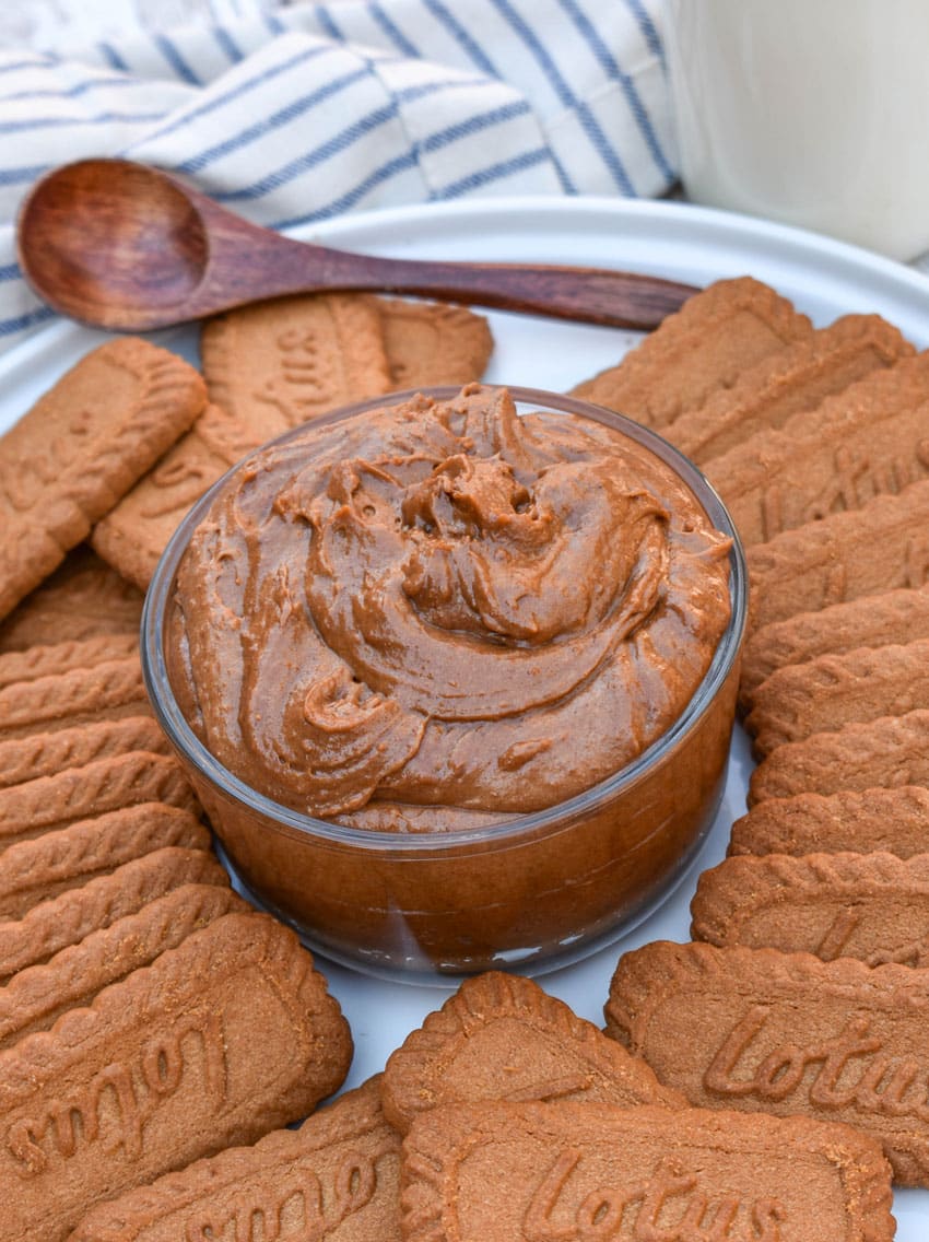 homemade creamy cookie butter in a small glass bowl surrounded by biscoff cookies