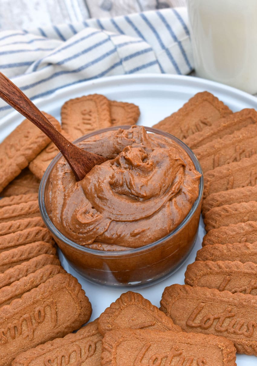 homemade creamy cookie butter in a small glass bowl surrounded by biscoff cookies