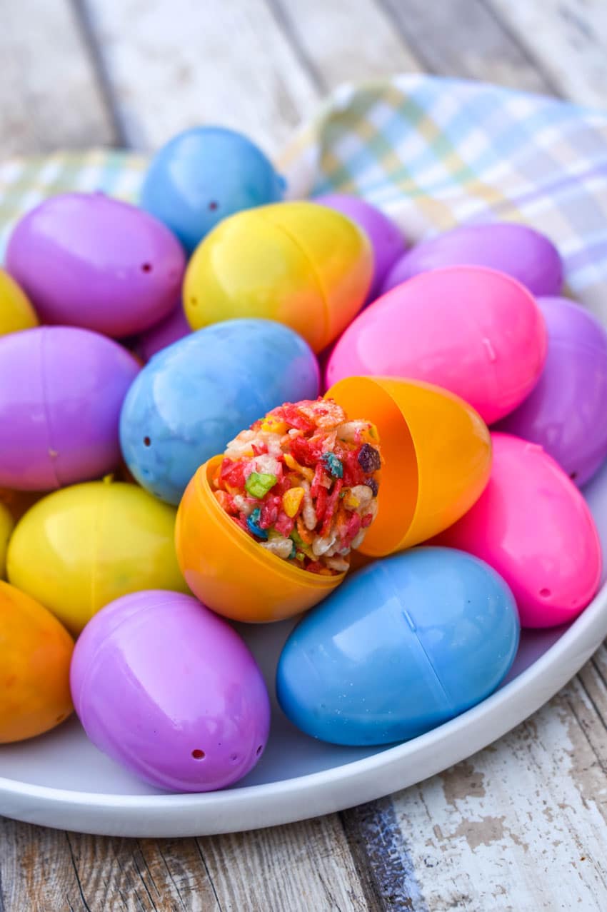 a pile of Rice Krispie Treats Easter Eggs in plastic egg shells on a white plate